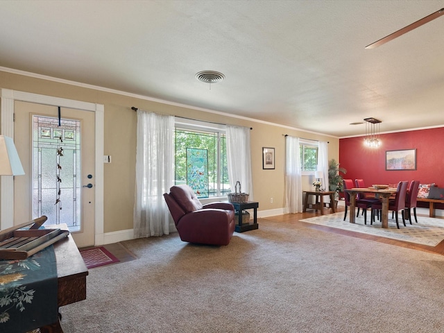 living room featuring crown molding, a healthy amount of sunlight, and carpet floors