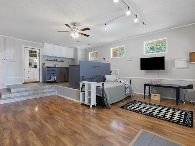 living room with ceiling fan, crown molding, hardwood / wood-style floors, and a textured ceiling