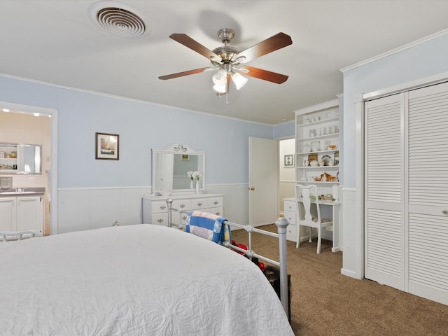 bedroom with connected bathroom, crown molding, carpet floors, a closet, and ceiling fan