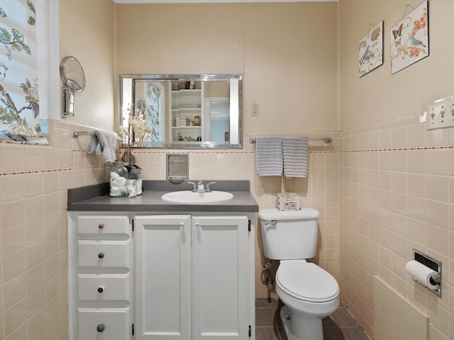 bathroom with tile patterned flooring, vanity, tile walls, and toilet