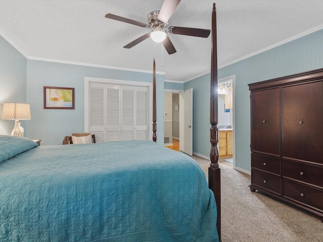 carpeted bedroom with ensuite bath, ceiling fan, ornamental molding, a textured ceiling, and a closet