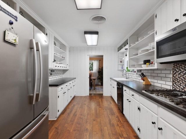 kitchen featuring white cabinetry, sink, backsplash, dark hardwood / wood-style flooring, and stainless steel appliances