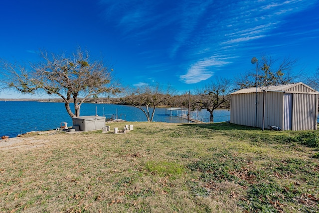 view of yard featuring a water view and an outbuilding