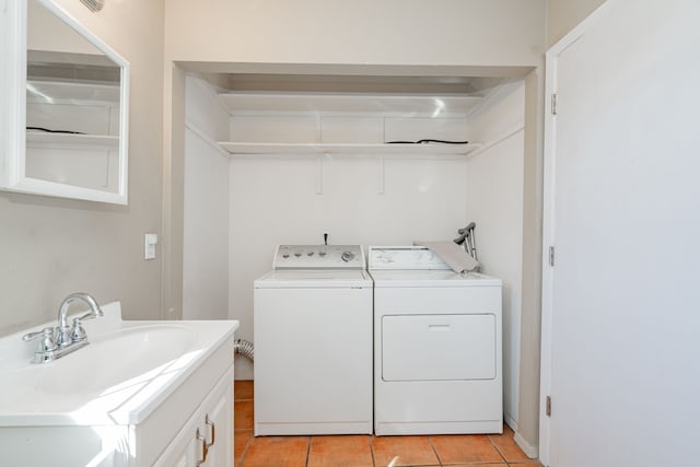 laundry room featuring washing machine and dryer, sink, and light tile patterned flooring