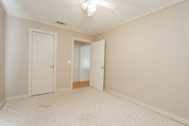 unfurnished bedroom featuring light carpet and ceiling fan