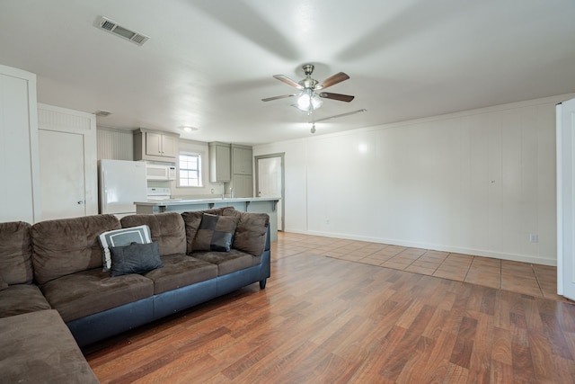 living room featuring wood-type flooring and ceiling fan