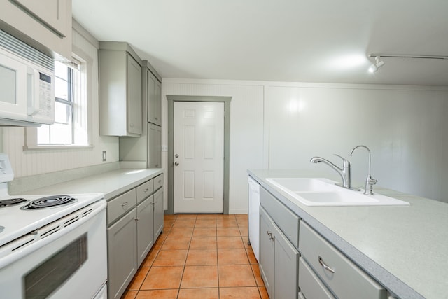 kitchen featuring sink, white appliances, gray cabinets, light tile patterned floors, and rail lighting