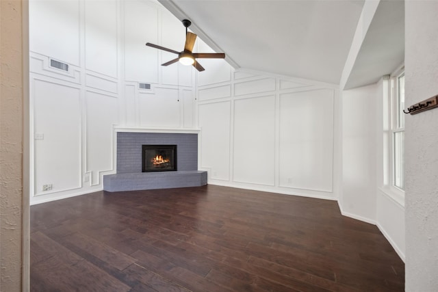 unfurnished living room with a fireplace, dark wood-type flooring, ceiling fan, and lofted ceiling