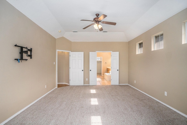 unfurnished bedroom featuring lofted ceiling, connected bathroom, and light colored carpet