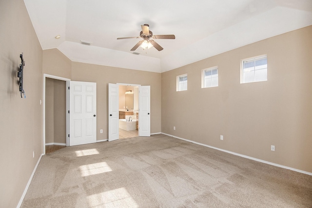 unfurnished bedroom with light carpet, ensuite bathroom, ceiling fan, and lofted ceiling