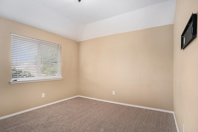 unfurnished room featuring lofted ceiling and carpet floors