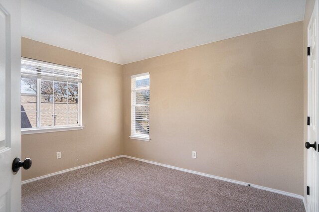 carpeted spare room with lofted ceiling