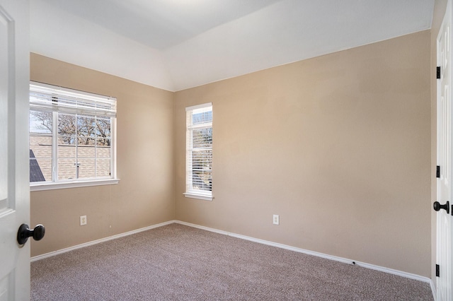 spare room with vaulted ceiling and carpet