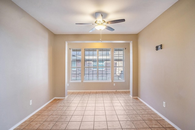 tiled spare room featuring ceiling fan