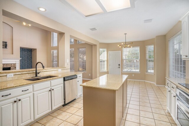 kitchen featuring appliances with stainless steel finishes, light tile patterned floors, white cabinetry, and hanging light fixtures