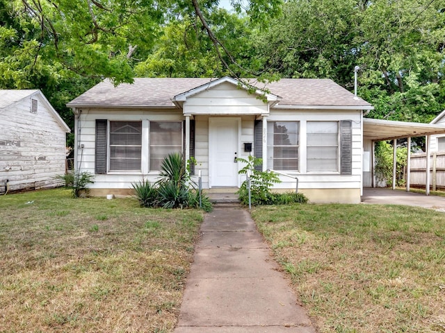 bungalow-style home with a front lawn and a carport