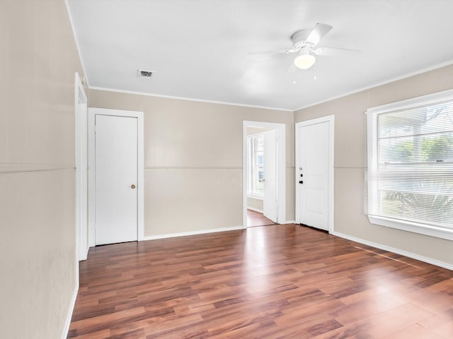 unfurnished room with dark hardwood / wood-style flooring, ceiling fan, and crown molding