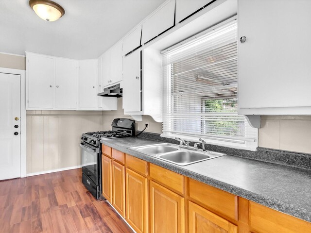 kitchen with gas stove, sink, white cabinets, and dark wood-type flooring