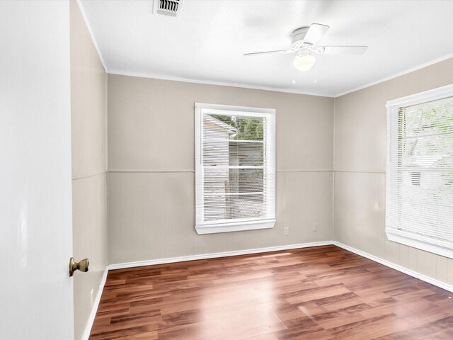 empty room with wood-type flooring, a wealth of natural light, and ceiling fan