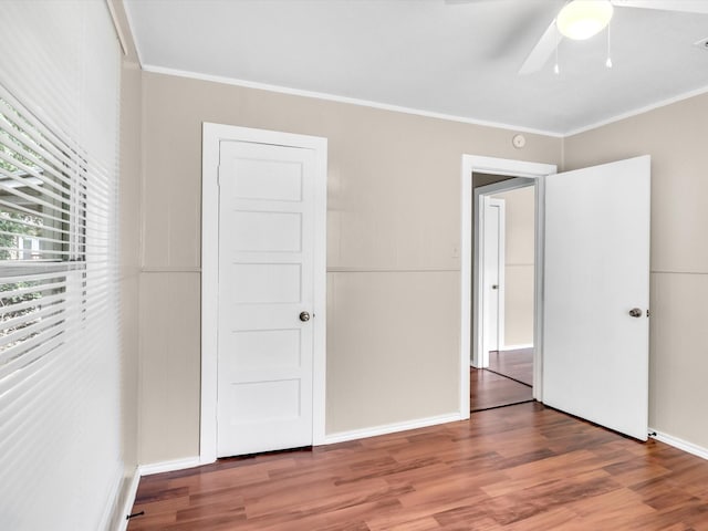 unfurnished bedroom with a closet, hardwood / wood-style flooring, ceiling fan, and ornamental molding