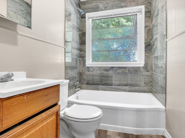 bathroom featuring toilet, vanity, tile walls, and hardwood / wood-style flooring