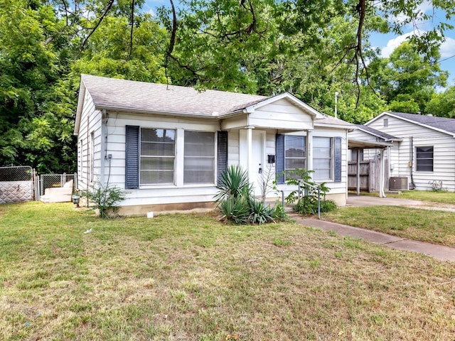 view of front of property with central AC unit and a front yard