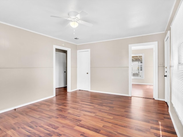 spare room with ceiling fan, dark hardwood / wood-style flooring, and ornamental molding