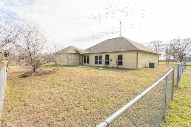 rear view of property featuring cooling unit and a yard