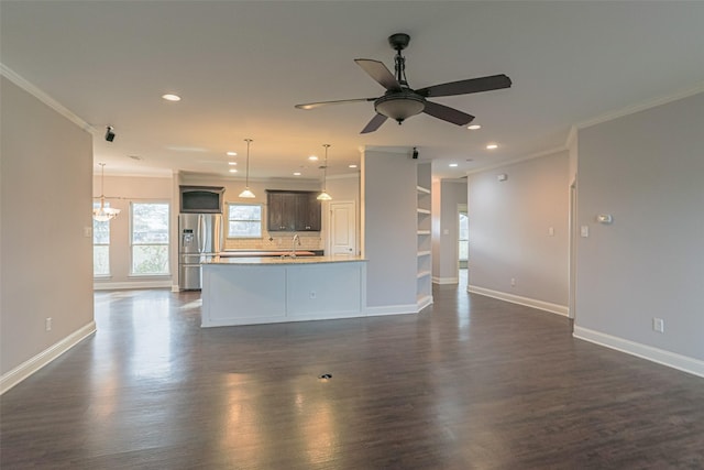 unfurnished living room with ornamental molding, dark wood-type flooring, and ceiling fan with notable chandelier