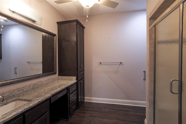 bathroom featuring hardwood / wood-style flooring, vanity, a shower with door, and ceiling fan