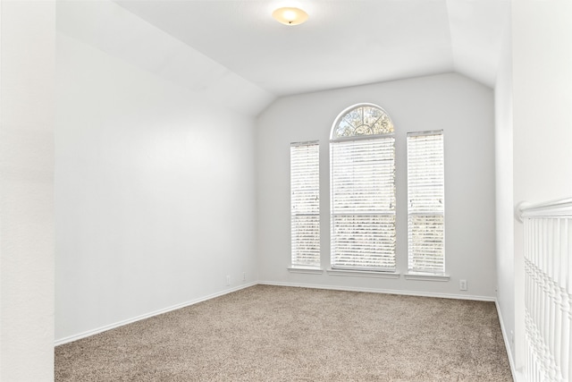 carpeted spare room with lofted ceiling