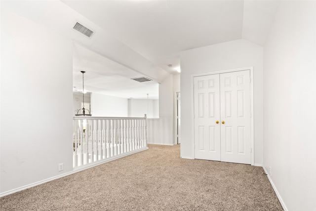 unfurnished room with lofted ceiling and carpet floors