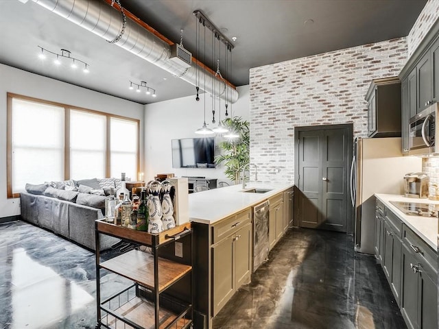 kitchen with kitchen peninsula, gray cabinets, sink, and hanging light fixtures