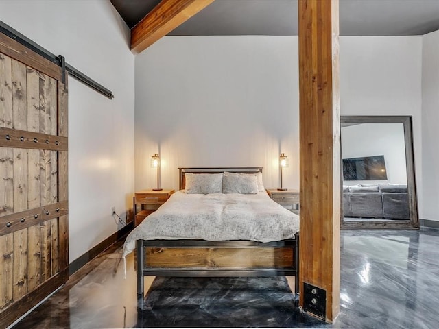 bedroom featuring beamed ceiling, a barn door, and concrete floors