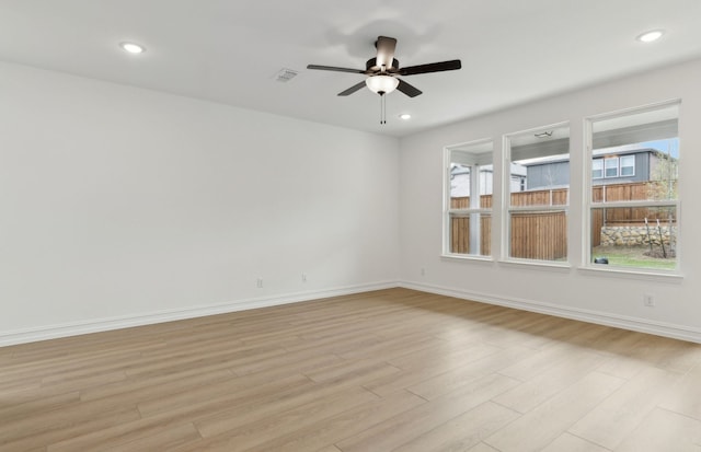bathroom with toilet, vanity, wood finished floors, and visible vents