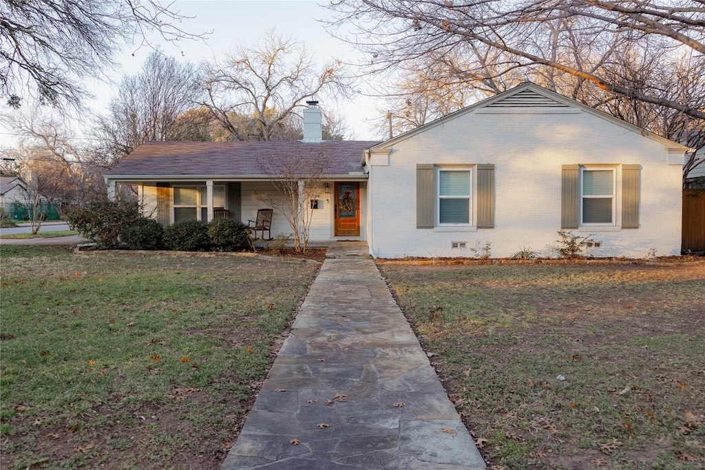 ranch-style home featuring a front lawn