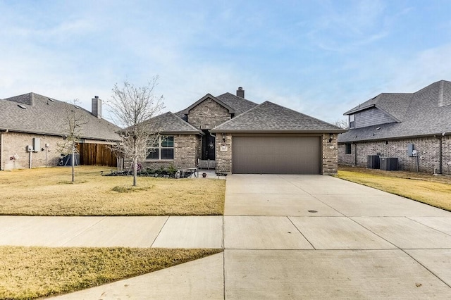 view of front of home with a front lawn, cooling unit, and a garage