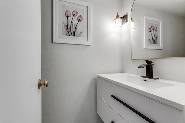 bathroom featuring a textured wall and vanity