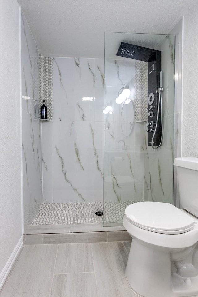 bathroom with toilet and a marble finish shower