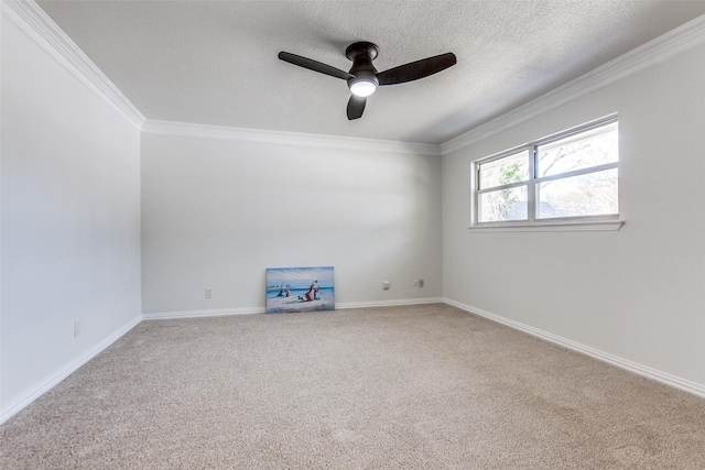 empty room with carpet, ornamental molding, a ceiling fan, a textured ceiling, and baseboards