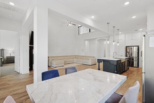 dining space featuring ceiling fan, light hardwood / wood-style floors, and sink