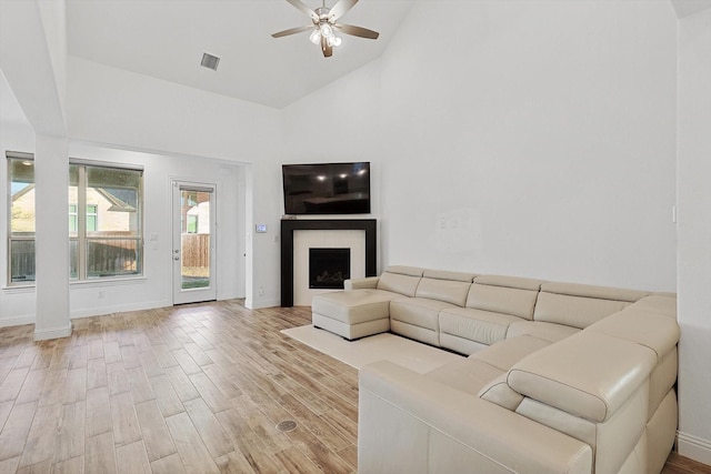 unfurnished living room with high vaulted ceiling, light hardwood / wood-style floors, and ceiling fan