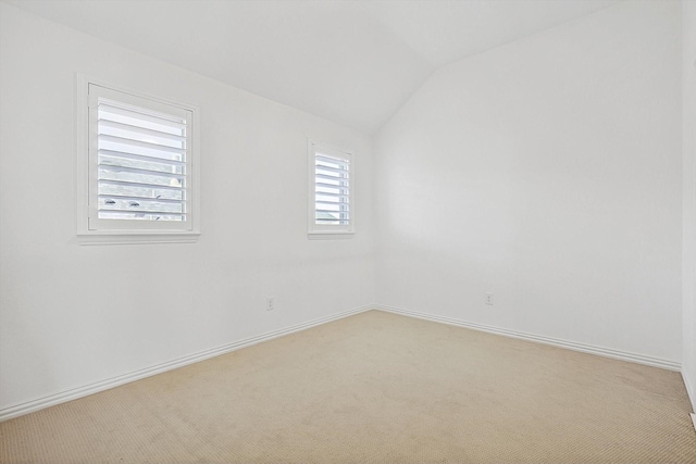 empty room with light carpet and vaulted ceiling