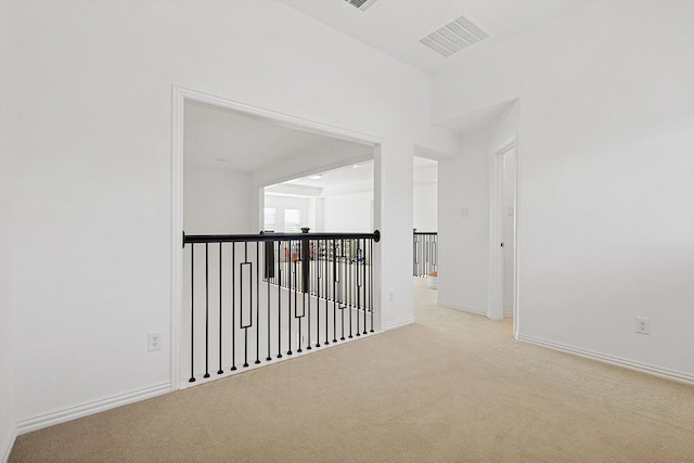 hallway featuring light colored carpet