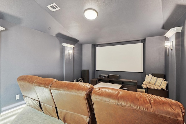 cinema room featuring carpet flooring, decorative columns, and a textured ceiling