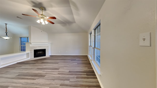 unfurnished living room featuring ceiling fan, light wood-type flooring, lofted ceiling, and a fireplace