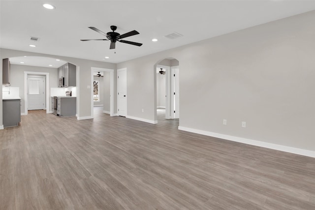 unfurnished living room featuring ceiling fan and wood-type flooring