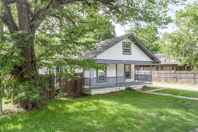 back of property with a lawn and covered porch