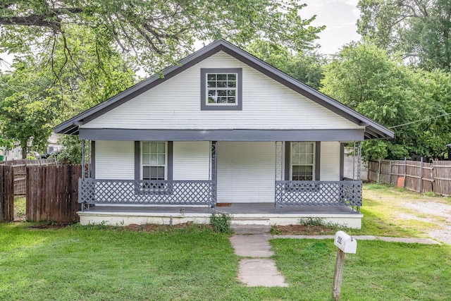 bungalow-style home with covered porch and a front lawn