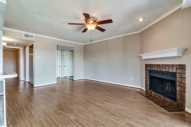 unfurnished living room with a tiled fireplace, ornamental molding, hardwood / wood-style flooring, and ceiling fan